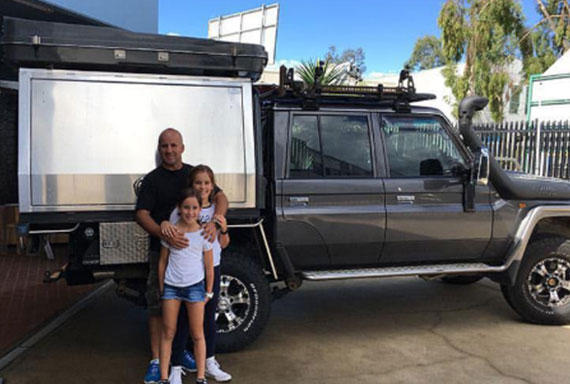 father and two children in front of Hilux