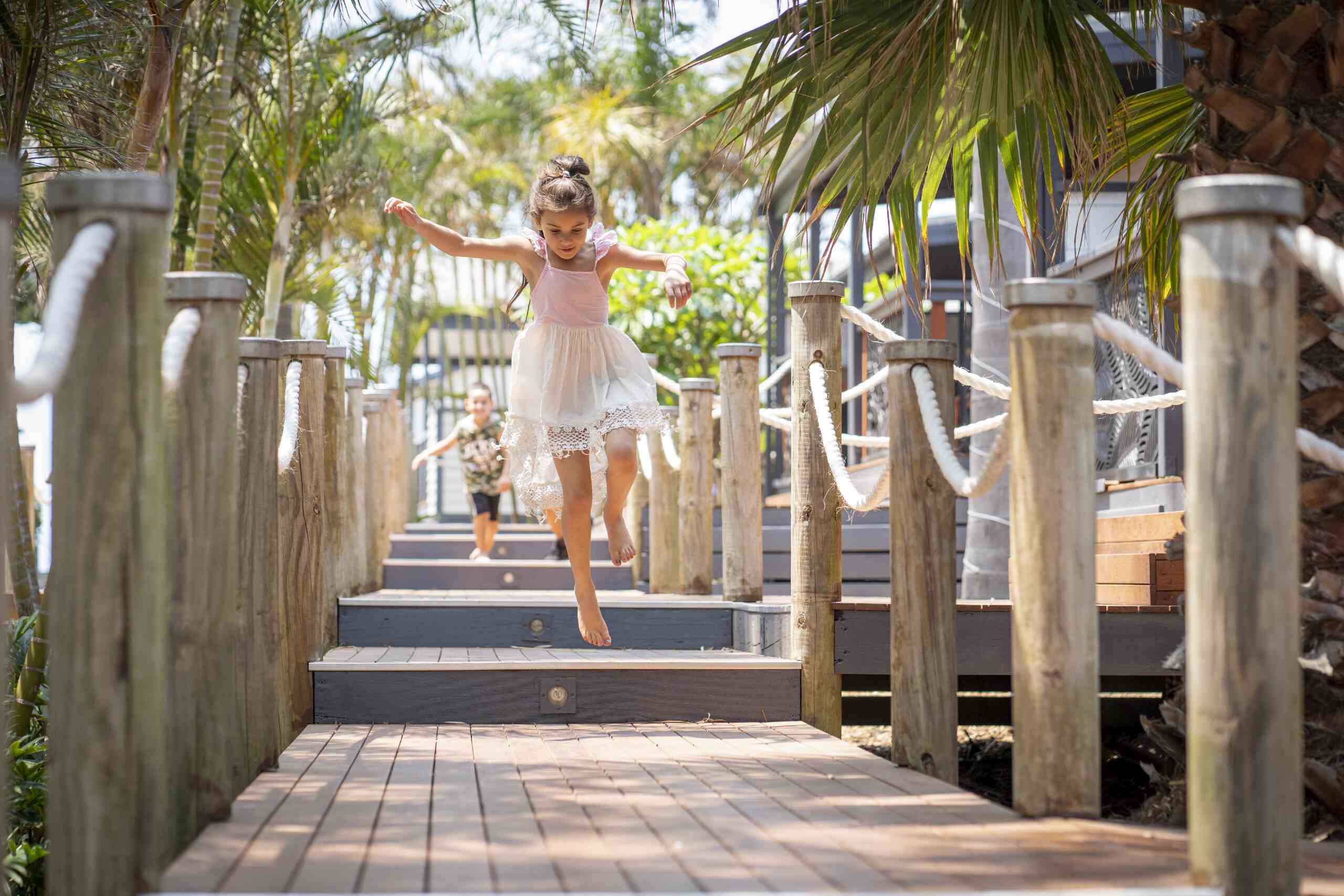 two children running along the wooden board walks