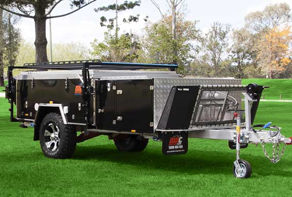 black camper trailer packed down in a field