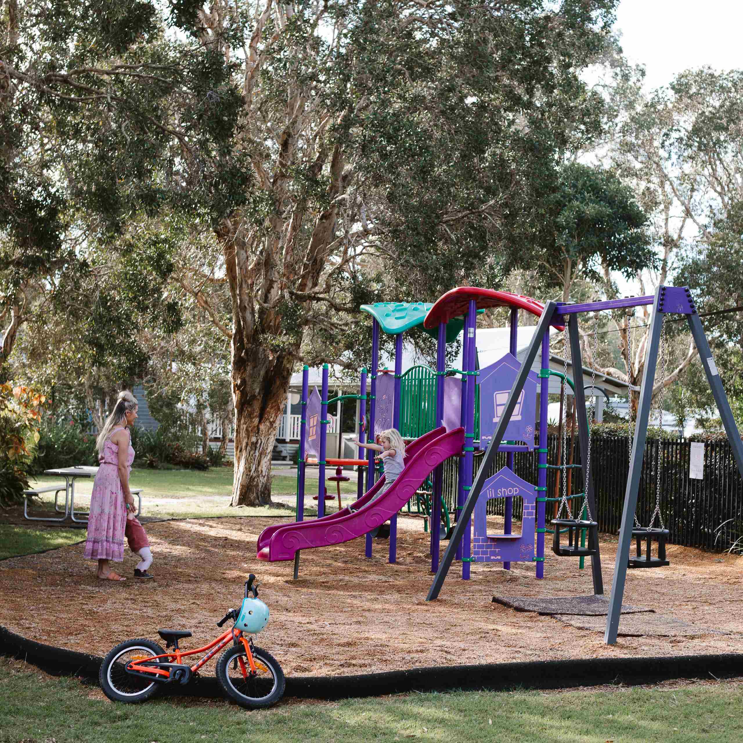 mother with two children playing on play ground equipment