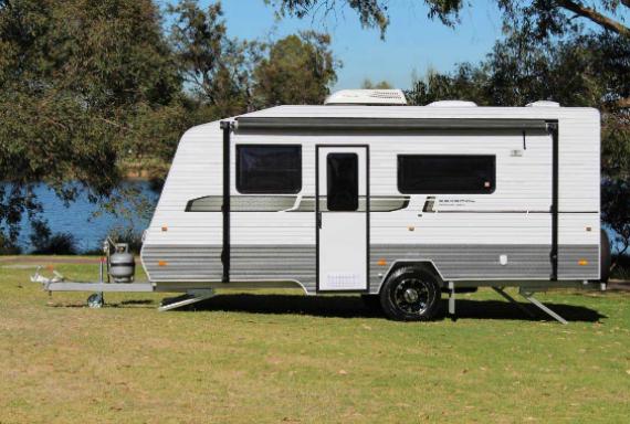 caravan parked on grass near water