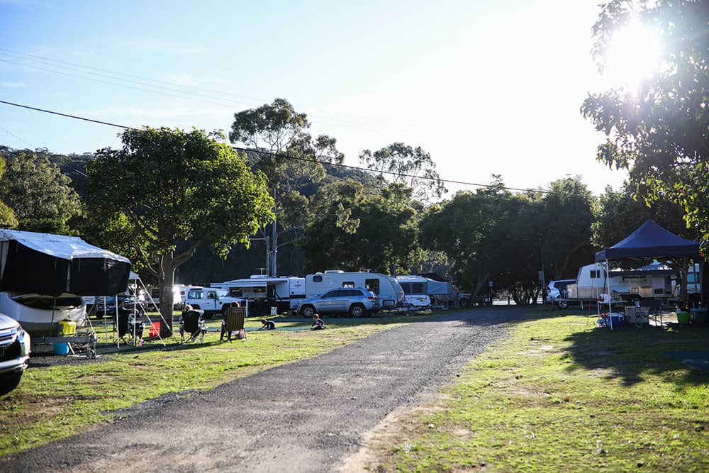 road inside park with people camping and caravans