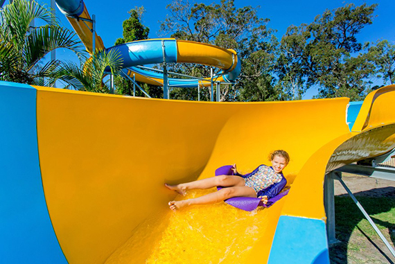 Smiling child having fun going down a water slide