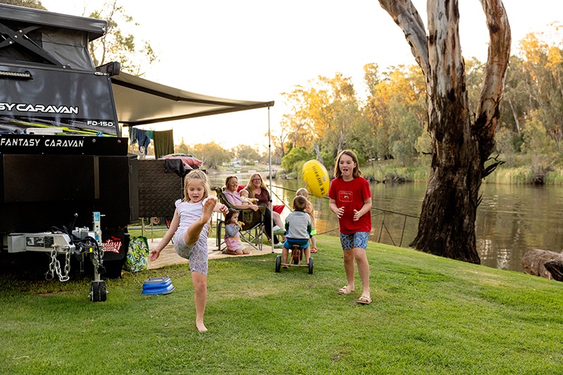 BIG4 Deniliquin Holiday Park children playing near caravan on waters edge