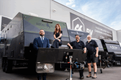 Team members posing in front of a line of new caravans at 4K RV.